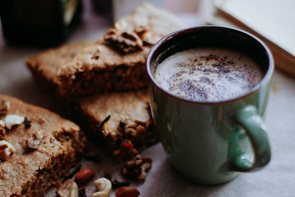 Delicious warm coffee served with slices of nutty carrot cake, perfect for a cozy treat.
